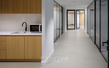 Interior view of office space rental at Paradijslaan 30-38, Eindhoven Center, featuring a hallway with private offices and a kitchenette area.