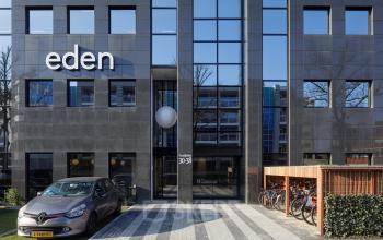 Exterior view of the office building at Paradijslaan 30-38, Eindhoven Center, featuring parking spaces and bicycle racks. Ideal for office space rental.