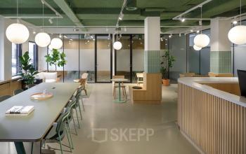 Modern office space for rent at Paradijslaan 30-38 in Eindhoven Center with contemporary furnishings, long tables, and potted plants.