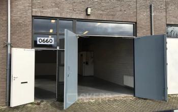 Exterior of an office building at Kanaaldijk-Zuid 19, Eindhoven Center, Eindhoven, with open large doors showing an unfurnished interior space.