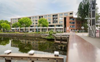 Exterior view of the office building at Kanaaldijk-Zuid 19, in Eindhoven Center, Eindhoven, with water and trees in the foreground.