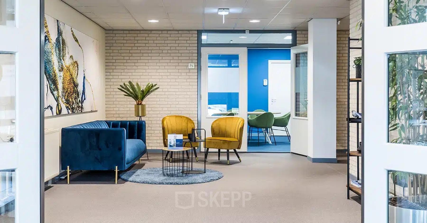 Modern office lounge area at Kanaaldijk-Zuid 19, Eindhoven Center, with stylish furniture and bright decor, highlighting available office space rental.
