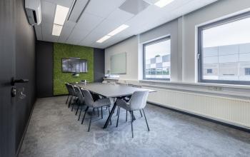 Modern office space with a long meeting table and chairs at Meerenakkerplein 1-10, Eindhoven De Hurk, ideal for office space rental.