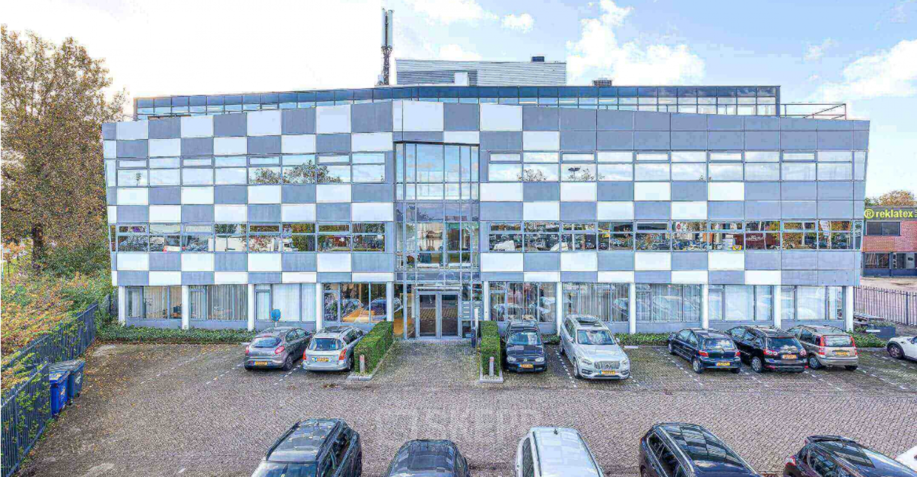 Exterior view of a modern office building at Meerenakkerplein 1-10, Eindhoven De Hurk, with parking spaces available for office space rental.