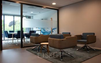 Cozy office space rental at Hurksestraat 60, Eindhoven De Hurk, featuring modern seating and a glass-walled conference room in the background.