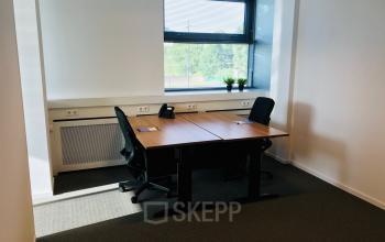 Office space rental at Hurksestraat 60, Eindhoven De Hurk featuring desks, chairs, phone, and window with blinds.