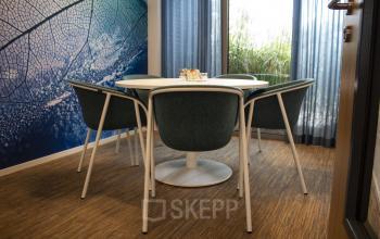 Modern office space rental at Hurksestraat 60 in Eindhoven De Hurk with a round table and five chairs in front of a large window.