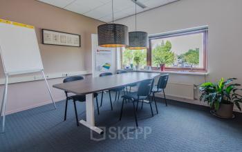 Office space rental at Le Havre 114-127 in Eindhoven North with a meeting table, chairs, whiteboard, potted plant, and window view.