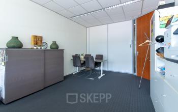 Interior office space at Le Havre 114-127, Eindhoven North, featuring a small meeting table, cabinets, and office decor.