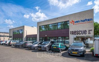 Exterior view of office building located at Le Havre 114-127, in Eindhoven North, Eindhoven, with several parked cars in front. Office space rental available.