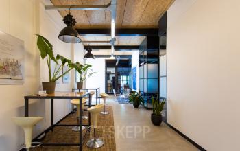 Bright interior office space at Weegschaalstraat 3, Eindhoven North, featuring high ceilings, modern furniture, and plants, available for rent.