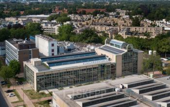 Aerial view of the modern office building at Frederiklaan 10A, Eindhoven Strijp-S, showcasing its expansive glass facade, ideal for office space rental.
