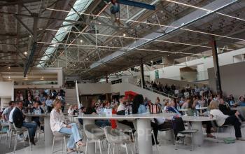 Spacious interior hall at Frederiklaan 10A, Eindhoven Strijp-S, featuring multiple attendees seated at tables, ideal for office space rental and collaborative events.