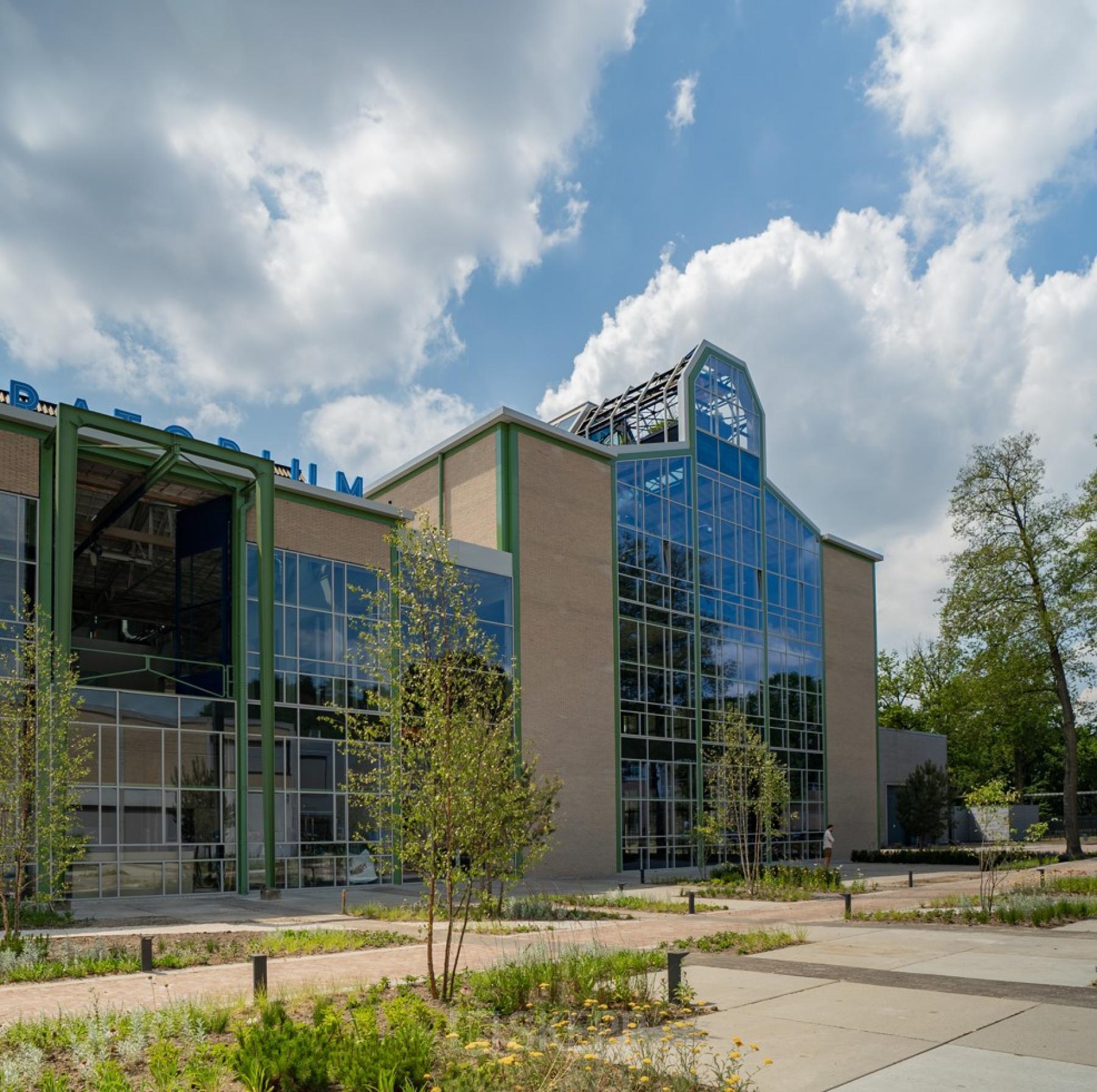 Exterior view of a modern office building at Frederiklaan 10A, Eindhoven Strijp-S, featuring large glass windows and surrounded by greenery. Perfect for office space rental.