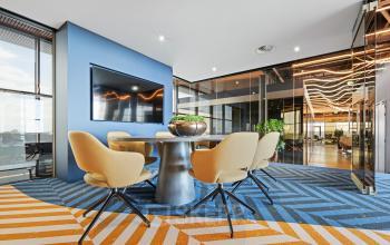 A modern meeting room with a sleek table, chairs, and a large TV in an office to rent at Achtseweg Zuid 159R, Eindhoven Strijp-S.