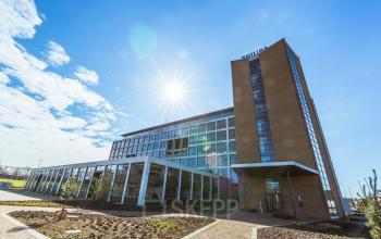 Exterior view of the office building at Achtseweg Zuid 159R, Eindhoven Strijp-S, showcasing a modern structure with clear skies, ideal for office space rental.