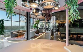 Modern office space for rent in Eindhoven Strijp-S, featuring stylish furniture, large windows, and contemporary lighting. Ideal for businesses seeking a dynamic work environment.