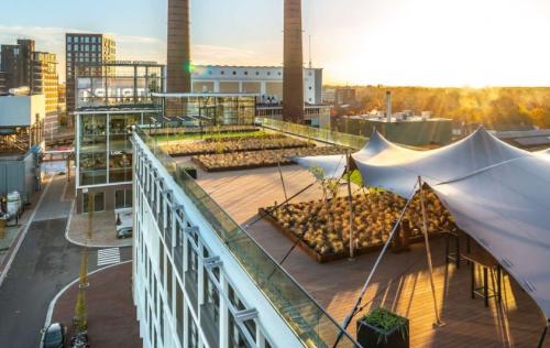 Rooftop view of Achtseweg Zuid 159R, Eindhoven Strijp-S with modern canopy and urban scenery, highlighting an attractive office space rental option.