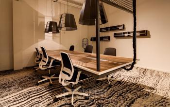 Spacious office to rent at Frederiklaan 10E, Eindhoven Strijp-S, featuring a modern conference room setup with a large wooden table and contemporary chairs.