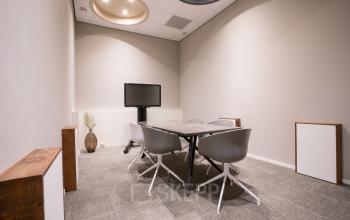 Modern office space for rent at Torenallee 20 in Eindhoven Strijp-S, featuring a conference table and chairs in a well-lit room.