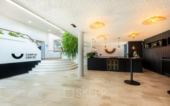 Spacious reception area at Brouwerijstraat 1, Enschede, featuring stylish decor and a modern design. The room is bright and welcoming, ideal for businesses seeking office space rental.