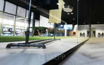 Modern interior office space at Hoedemakerplein 2, Enschede, featuring sleek glass partitions, a polished wooden floor, and stylish decor. Ideal for office space rental with bright lighting and contemporary design.