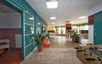 Spacious office to rent at Boddenkampsingel 95, Enschede, featuring modern workspaces with vibrant decor and greenery. Ideal for office space rental.