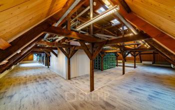Spacious attic office at Prins Hendrikkade 3, Franeker, featuring wooden beams and carpet flooring, ideal for office space rental.