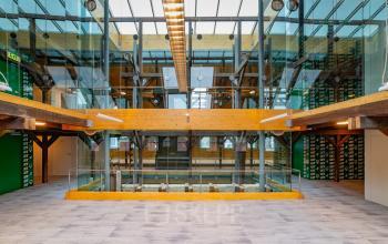 Bright office space with glass walls, exposed beams, and skylights at Prins Hendrikkade 3, Franeker, ideal for office space rental.
