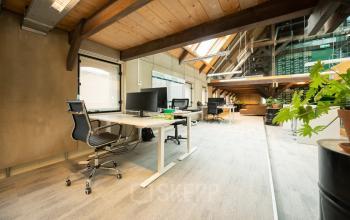 Office space at Prins Hendrikkade 3, Franeker, featuring a bright interior with modern workstations, natural wooden beams, and large windows. Ideal for office space rental.