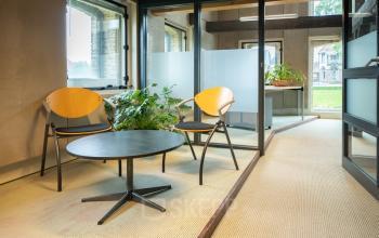 Cozy office space with seating area and greenery at Prins Hendrikkade 3, perfect for rent office space opportunities.