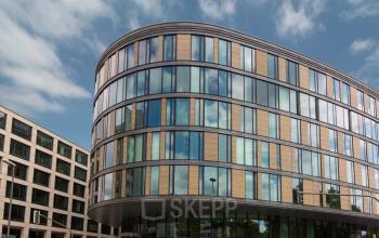 Modernes Bürogebäude Baseler Straße 10 am Frankfurt Hauptbahnhof mit Glasfassade und abgerundeten Ecken.
