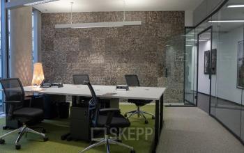 Modernes Büro in der Baseler Straße 10, Frankfurt Hauptbahnhof mit mehreren Arbeitsplätzen, ergonomischen Stühlen und direktem Zugang zu einem Konferenzraum. Ideal, um eine Bürofläche zu mieten.