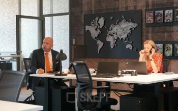 Geschäftsleute arbeiten in einem modern eingerichteten Büro in der Neue Mainzer Straße 46-50, Frankfurt Innenstadt. Weltkarte an der Wand.