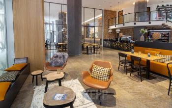 Moderne Lounge in Neue Mainzer Straße 46-50, Frankfurt Innenstadt, ideal für entspannte Pausen. Stilvolle Einrichtung mit verschiedenen Sitzbereichen und dekorativen Elementen.