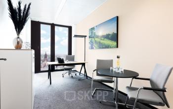 Modernes Büro zur Miete in der Neue Mainzer Straße 6, Frankfurt Innenstadt, mit Schreibtisch, Stühlen, und Blick auf die Stadt.