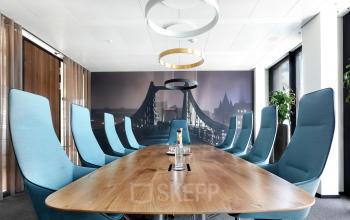 Moderner Konferenzraum im Büro in Neue Mainzer Straße 6, Frankfurt Innenstadt, Frankfurt, mit langen Holztisch und stilvollen blauen Stühlen.