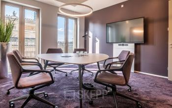 Moderner Konferenzraum in Frankfurt Innenstadt im Opernplatz 14. Der Raum ist möbliert mit einem runden Tisch und Stühlen, ideal um eine Bürofläche zu mieten für Meetings oder Präsentationen.