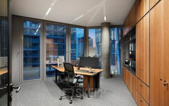 Modernes Büro in der Junghofstraße 9, Frankfurt Innenstadt, mit großen Fenstern, die einen Blick auf umliegende Gebäude bieten. Die Fläche ist möbliert und ideal zum Bürofläche mieten.