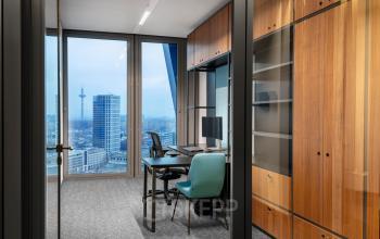 Modernes Büro mit Blick auf die Skyline in der Junghofstraße 9, Frankfurt Innenstadt. Ideal für Bürofläche mieten mit Schreibtischen, Stühlen und einem eleganten Holzschrank.