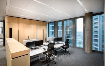 Moderner Büroraum in der Junghofstraße 9, Frankfurt Innenstadt, mit großen Fenstern und mehreren Arbeitsplätzen, ideal zum Büro mieten.