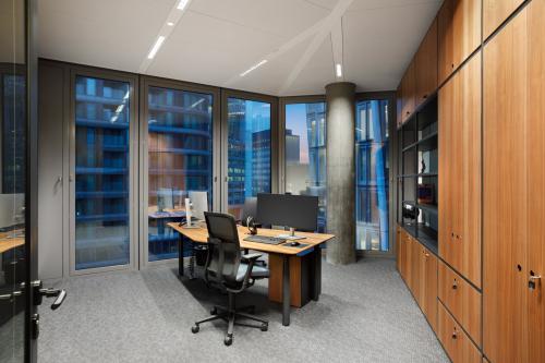 Modernes Büro in der Junghofstraße 9, Frankfurt Innenstadt, mit großen Fenstern, die einen Blick auf umliegende Gebäude bieten. Die Fläche ist möbliert und ideal zum Bürofläche mieten.