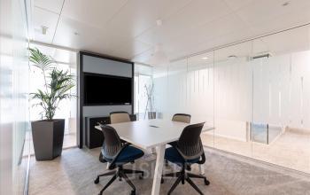 Modernes Büro mit Konferenztisch, Stühlen und Bildschirm im Esplanade de Pont-Rouge 4, Genf Grand-Lancy, ideal für geschäftliche Meetings und bürofläche mieten.