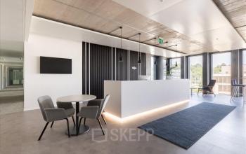 Moderne büroraum mieten in Genf Grand-Lancy Esplanade de Pont-Rouge 4 mit eleganter Einrichtung und Holzakzenten.