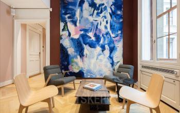 Stilvoller Büroraum mieten in Genf Innenstadt, großes Kunstwerk an der Wand, komfortable Sitzmöbel im Gesprächsbereich, Place de la Fusterie 12.