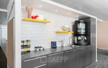 Moderne Büropantry mit Kaffeemaschine und Auswahl an Tee in Genf Innenstadt, ideale Ergänzung zur Bürofläche mieten in Rue du Commerce 4.