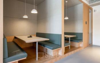 Moderne Büroraum mieten in Genf Les Genets, Rue du Pré-de-la-Bichette 1, mit Holzmöbeln und komfortabler Sitzbank.