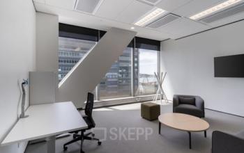 Modern gestalteter Büroraum mieten in Place Casa-Bamba 1-3, Genf Vernier, mit Schreibtisch, Stühlen und entspannender Lounge-Ecke