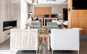 Moderne Lounge mit Sitzbereichen und arbeitender Person im Büro in Place Casa-Bamba 1-3, Genf Vernier.