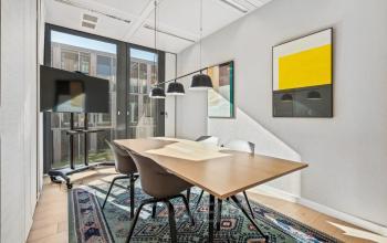 Moderner Konferenzraum in der Route de Meyrin 123, Genf Vernier, mit einem großen Holztisch und farbigen Wandbildern. Ideal, um Bürofläche zu mieten.